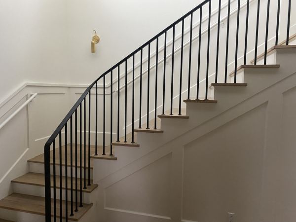 Ribbon Railing — Ribbon railing featuring 1/2" x 2" flat bar rail cap with heat formed transitions and termination 3/4" round rod pickets with 3/16" x 1 3/4" round escutcheons mounted directly to stair treads    
