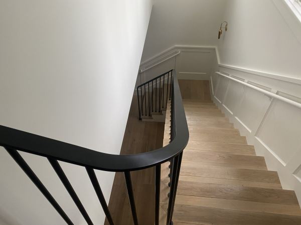 Ribbon Railing — Ribbon railing featuring 1/2" x 2" flat bar rail cap with heat formed transitions and termination 3/4" round rod pickets with 3/16" x 1 3/4" round escutcheons mounted directly to stair treads  