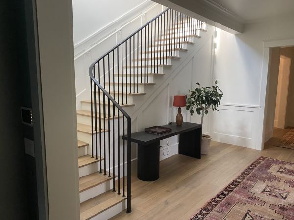 Ribbon Railing — Ribbon railing featuring 1/2" x 2" flat bar rail cap with heat formed transitions and termination 3/4" round rod pickets with 3/16" x 1 3/4" round escutcheons mounted directly to stair treads